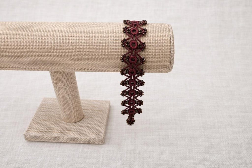 Delicate handmade crochet bracelet with beads and intricate weave. Burgundy.
