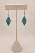 Earrings featuring genuine turquoise in sterling silver with subtle gold accents.