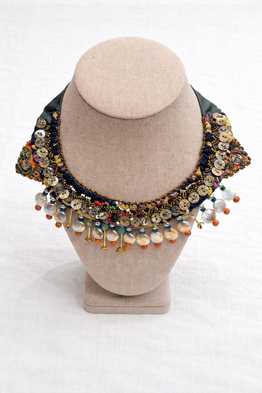 Handcrafted necklace blending vintage textile, coral and turquoise gemstones with mother of pearl.